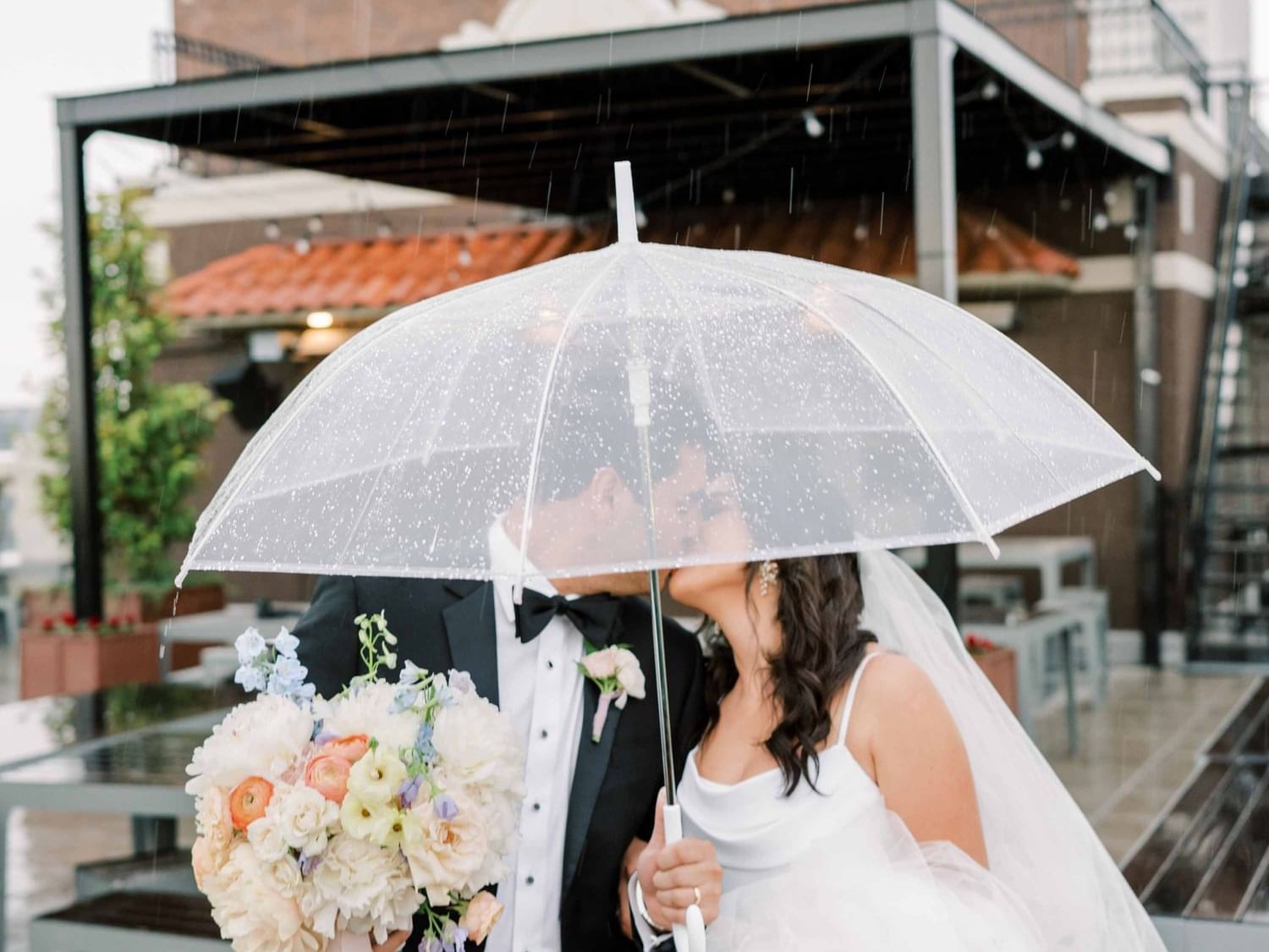 Close-up of wedded couple kissing on rooftop at The Mayo Hotel