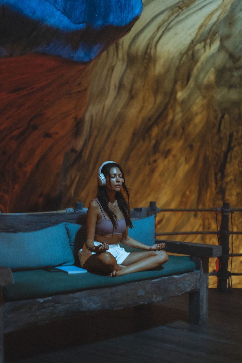 Lady meditating while wearing a headphone at The Banjaran Hotsprings Retreat