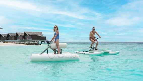 A pair of people navigating a stand-up paddle board near Grand Park Kodhipparu, Maldives