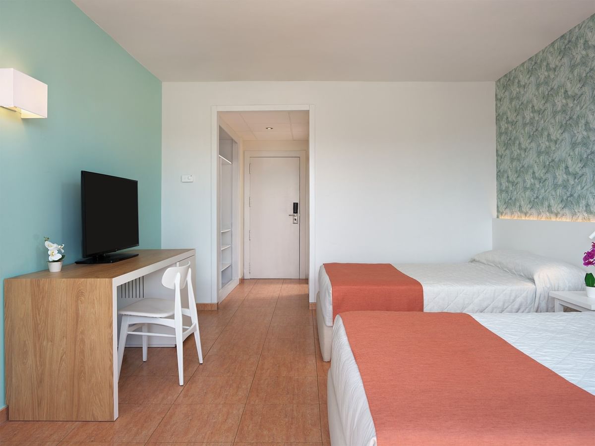 Adapted Standard Rooms featuring two large double beds and flat-screen television on a white desk at Ponient Pirámide Salou