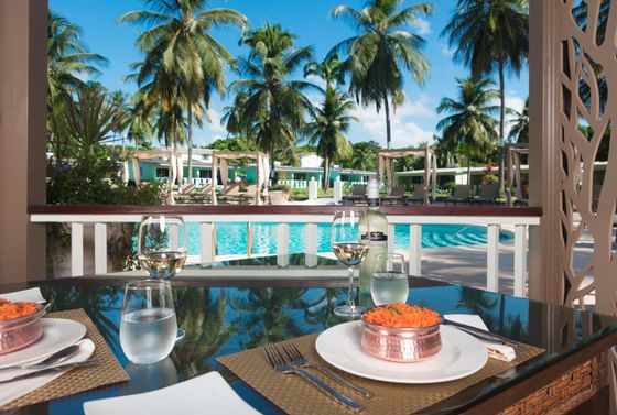 Dining area with dishes served on a table by swimming pool and lawn area at All Seasons Resort Europa