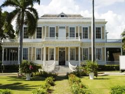 Exterior view of Devon House with green lawn near Jamaica Pegasus Hotel