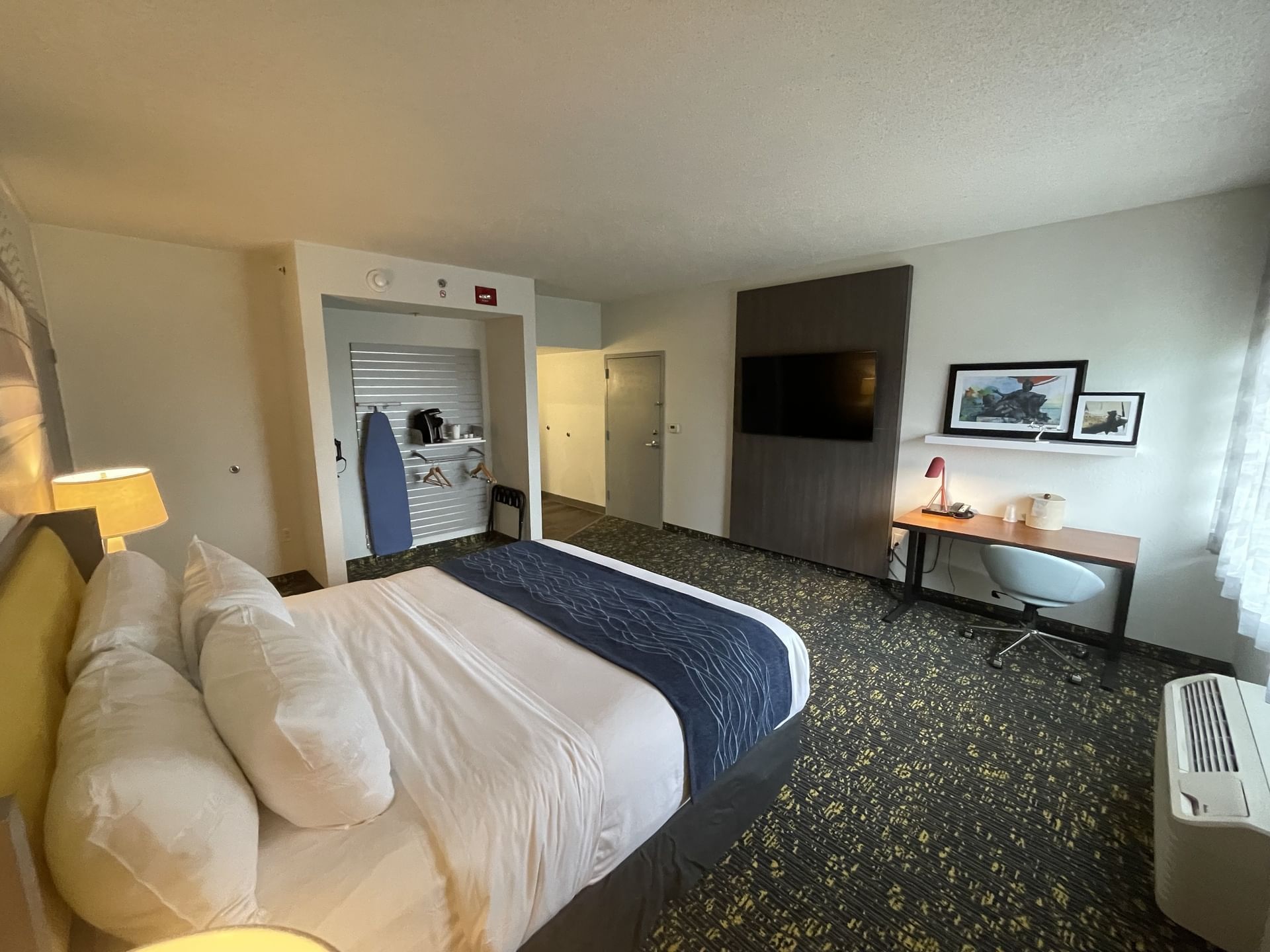 Bed, nightstand & workspace in Single King Handicap With Roll in Shower at St. Louis Airport Hotel
