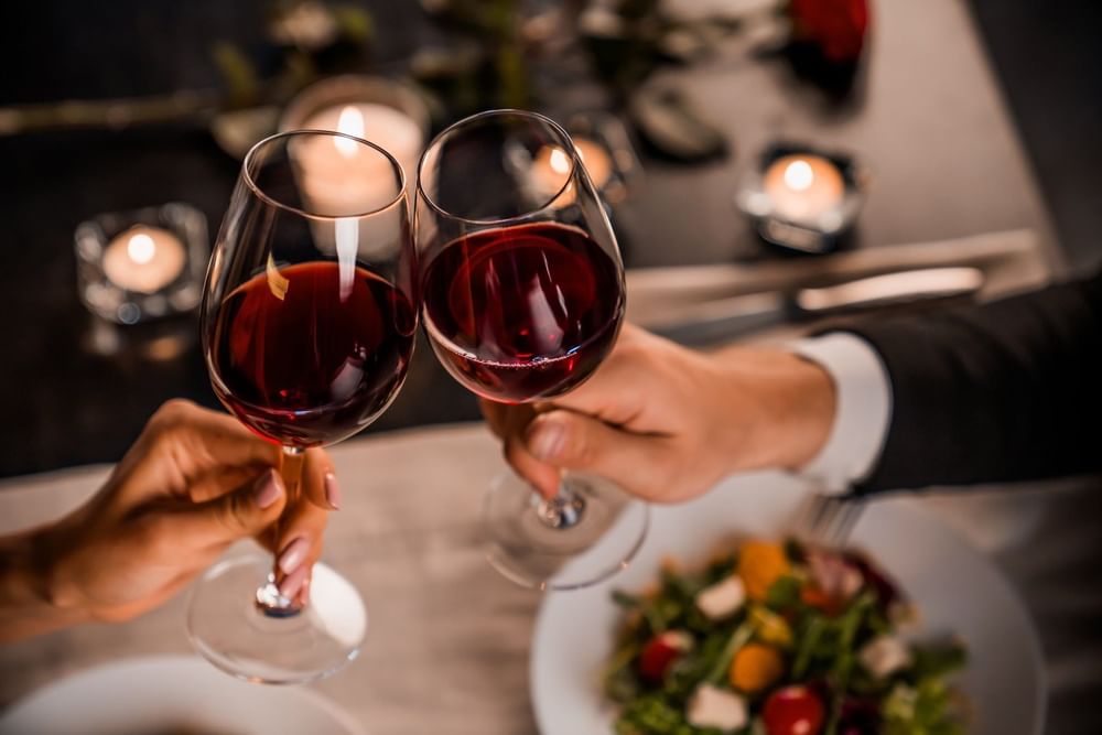 Close-up of toasting red wine at Curamoria Collection