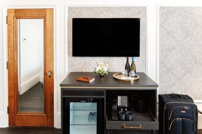 Mini fridge by a television counter near a suitcase at Rodd Charlottetown Hotel, one of the best hotel in PEI