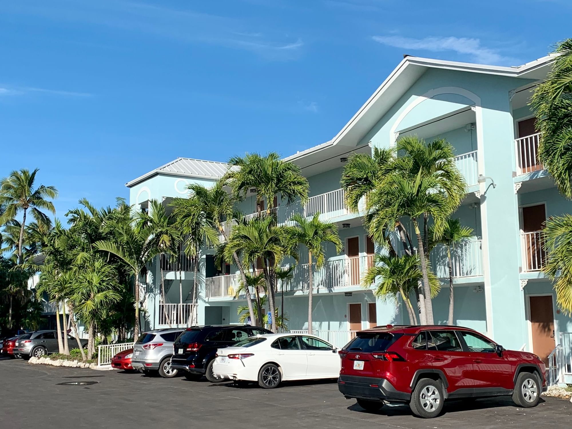 The Bayside Inn Key Largo with palm trees and cars parked in front.