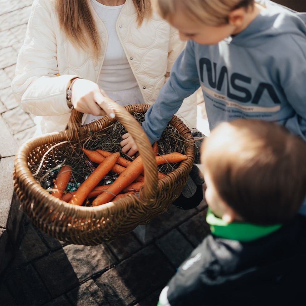 Bambini con un cesto di carote e una donna per l'offerta Magia di Pasqua al Lido