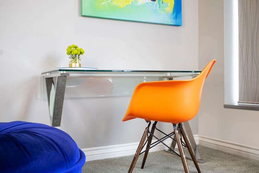 Floating desk with a chair & painting on the wall in King Premiere Pop at Retro Suites Hotel