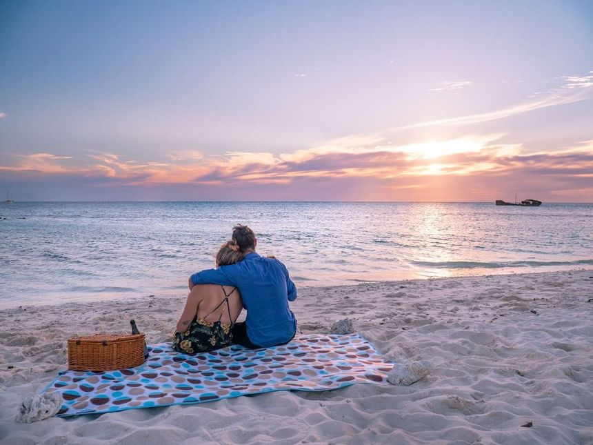 A couple at the beach watching sunset at Heron Island Resort