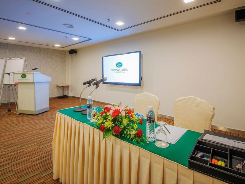 Conference room setup with microphones on a table with flowers at Sunway Hotel Georgetown