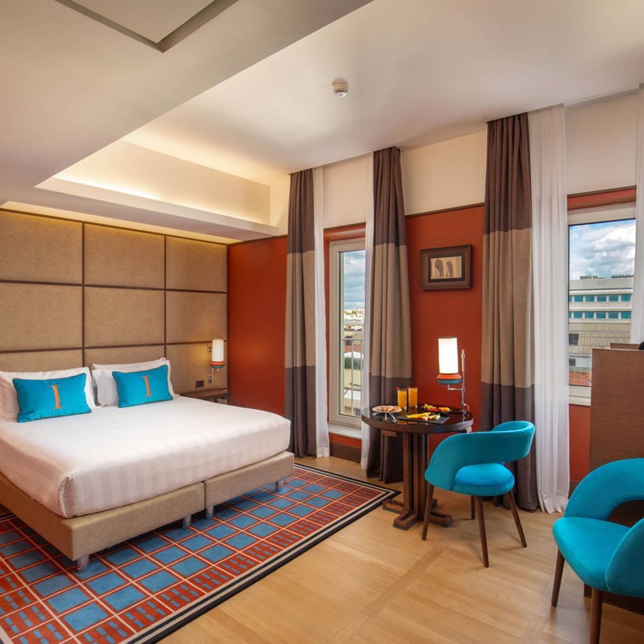 Modern Superior Room with a plush bed, wooden floors, and cozy seating by the window at The Independent