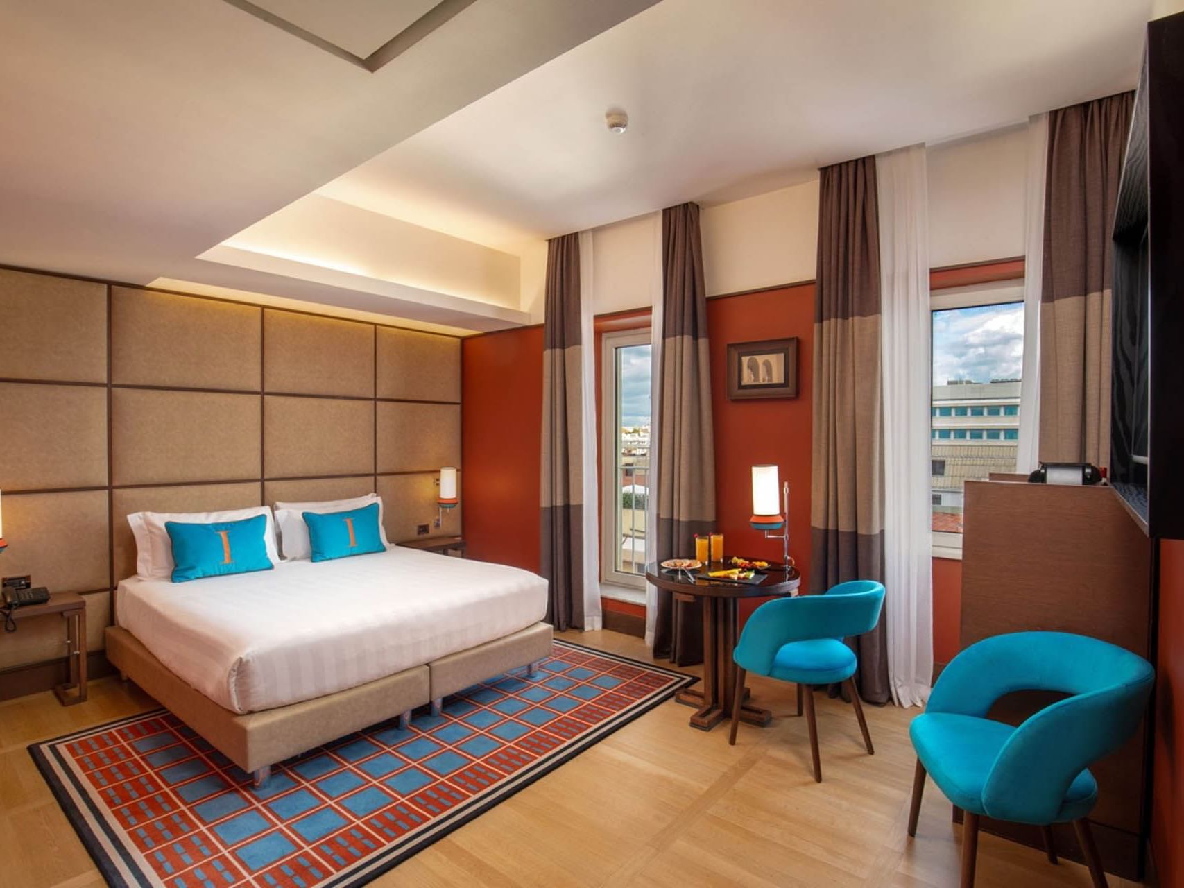 Modern Superior Room with a plush bed, wooden floors, and cozy seating by the window at The Independent