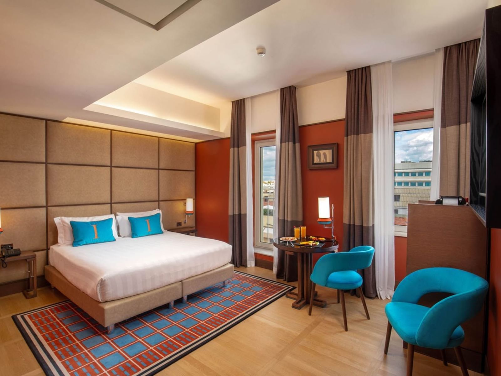 Modern Superior Room with a plush bed, wooden floors, and cozy seating by the window at The Independent