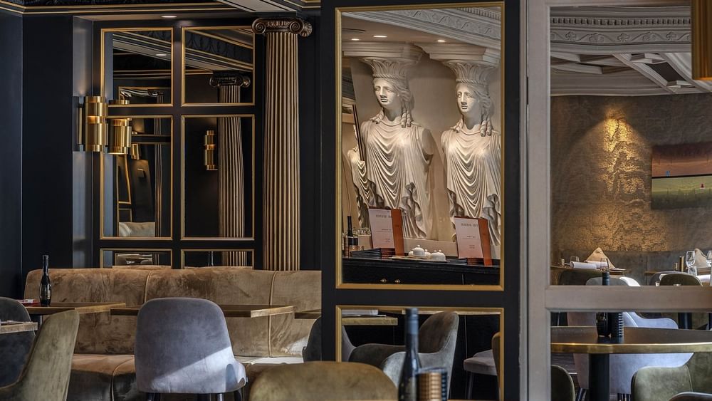 Sophisticated dining room with mirrors and upholstered chairs & sofas at Hotel Barsey by Warwick