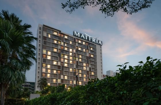 The exterior of Maitria Hotel Rama 9 Bangkok in the evening