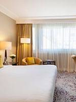 The Montaigne Suite features Desk with a gold lamp by a cozy armchair at Warwick Paris Champs Elysées