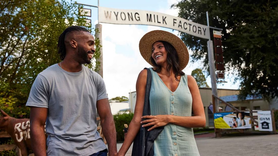A couple holding hands in front of Wyong Milk Factory near Mercure Kooindah Waters