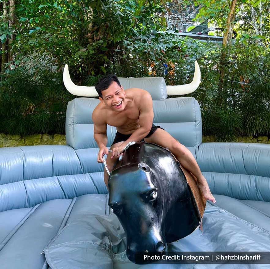 A man is joyfully riding a mechanical bull at Escape Penang Theme Park - Lexis Suites Penang