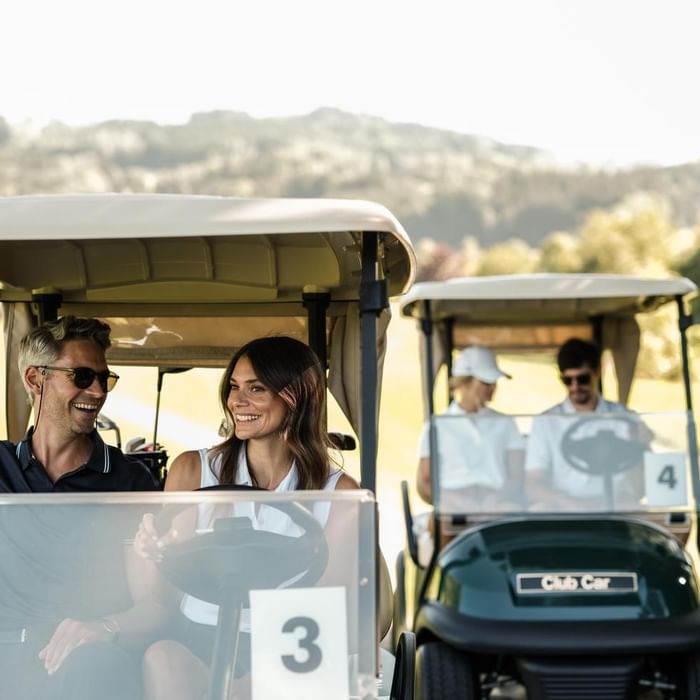 Two golf carts on a course with two couples at Falkensteiner Hotel Schladming