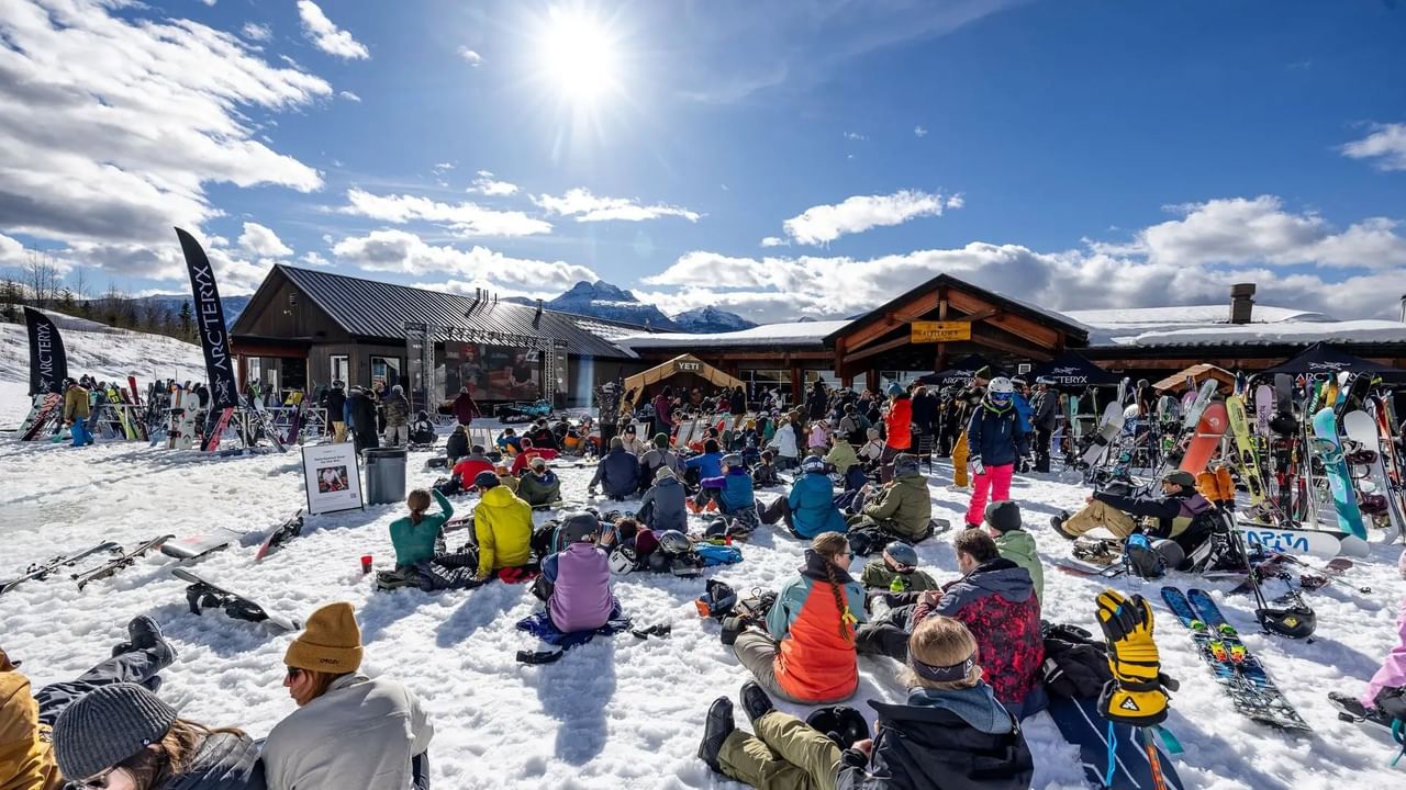 A lively crowd gathers on the snow at a ski resort for the Natural Selection Tour event.