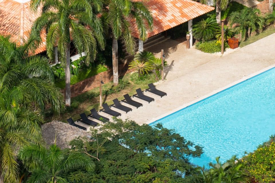 Outdoor pool with sun loungers & hotel at Club Hemingway