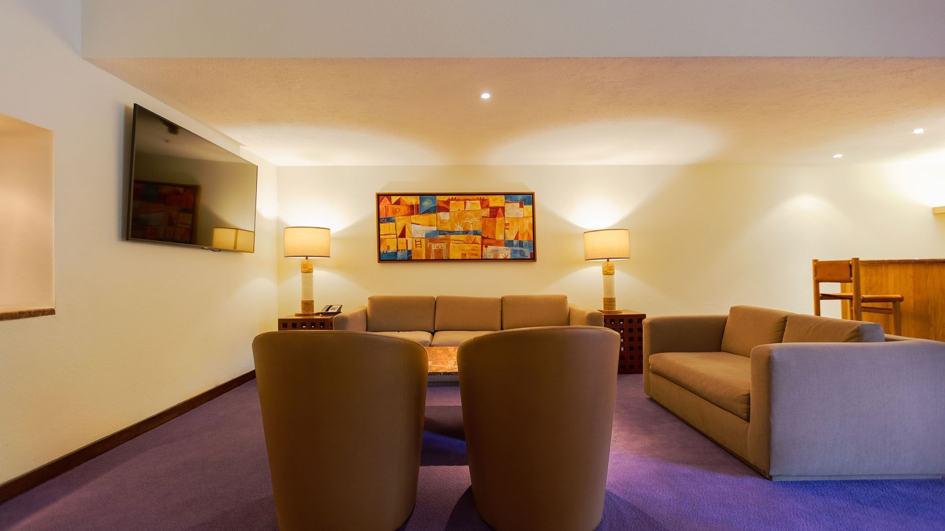 King Master Suite seating area featuring purple floors and colorful abstract art at Camino Real Polanco Mexico