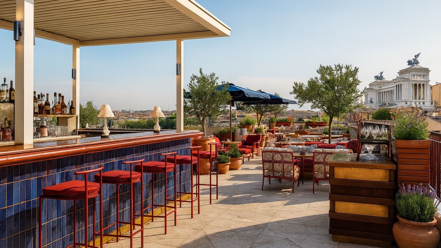 Lyve Rooftop Terrace at Thompson Rome with red stools and lounge seating, overlooking the city from a luxury hotel in Rome