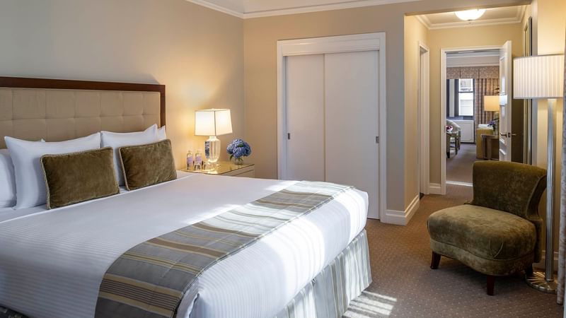 Cozy bed with chair in Premiere City View Suite at Warwick New York