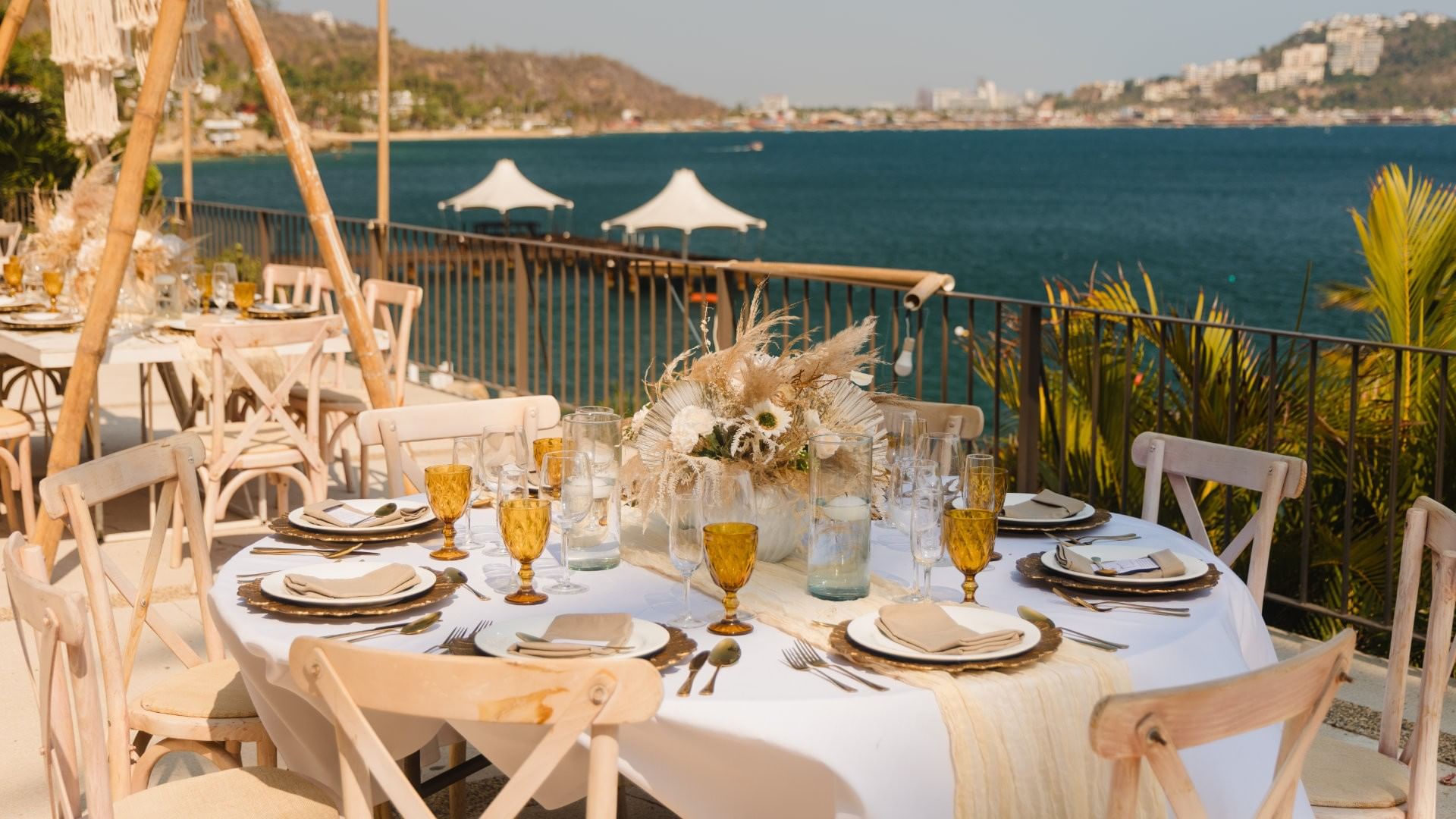 Camino Real II coastal dining table with amber glassware and view of the bay at Camino Real Acapulco Diamante