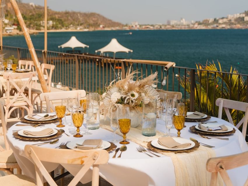 Coastal dining table with amber glassware and view of the bay at Camino Real II in Camino Real Acapulco Diamante