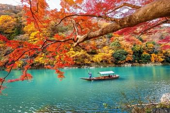 Boat on a lake with vibrant autumn near Park Hotel Kyoto