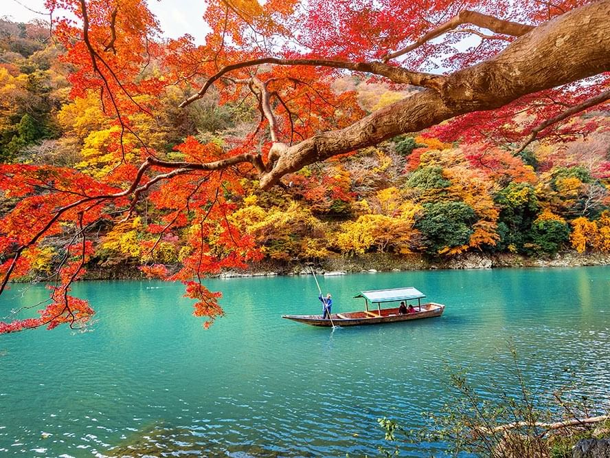 Boat on a lake with vibrant autumn near Park Hotel Kyoto