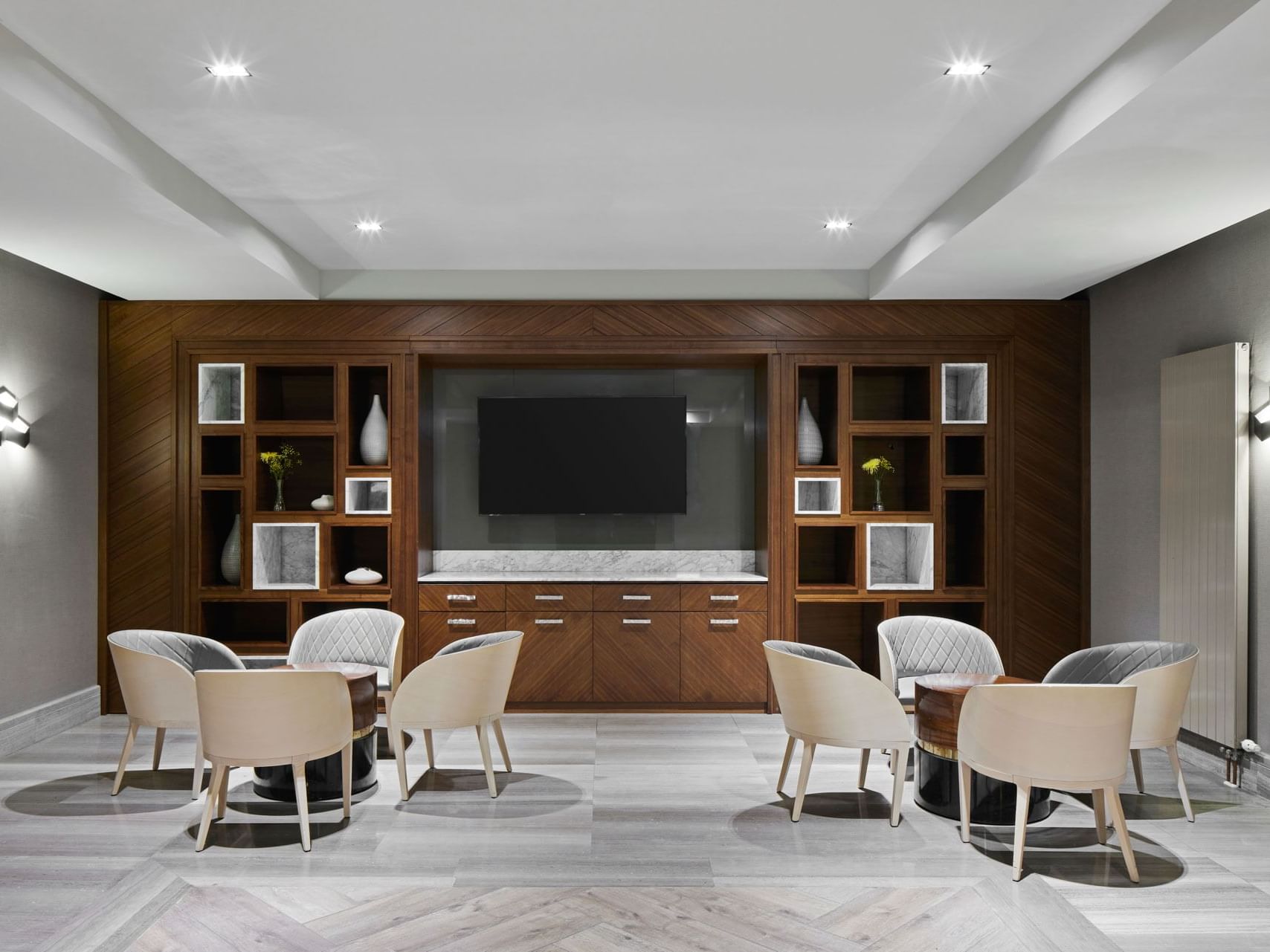 Modernes Esszimmer mit einem Holzschrank, Fernseher und rundem Tisch im Titanic Chaussee Berlin