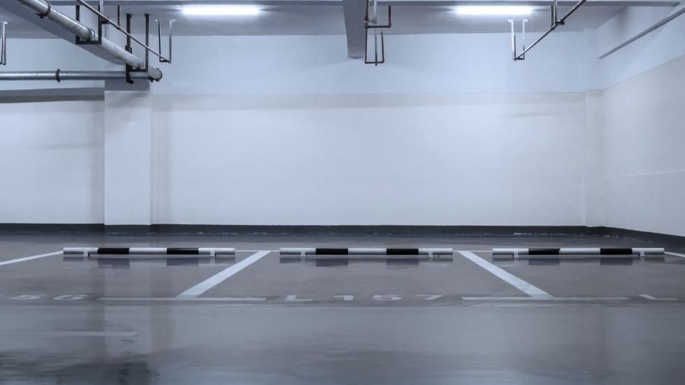 Empty parking lot with marked spaces and overhead pipes at Sunway Hotel Big Box