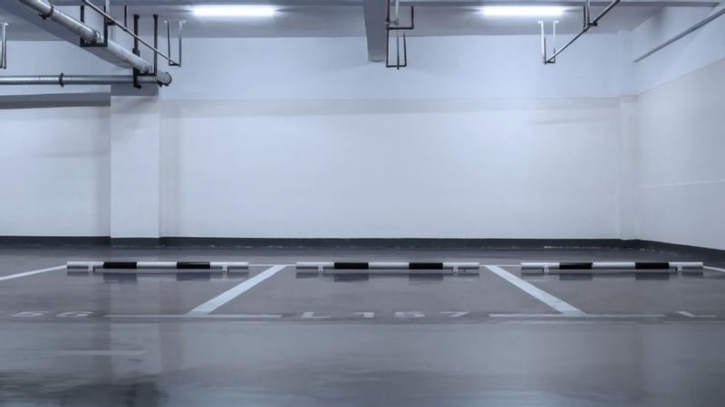 Empty parking lot with marked spaces and overhead pipes at Sunway Hotel Big Box