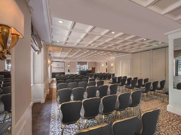 Theater set-up facing screen under warm light in Surrey meeting room at Warwick New York