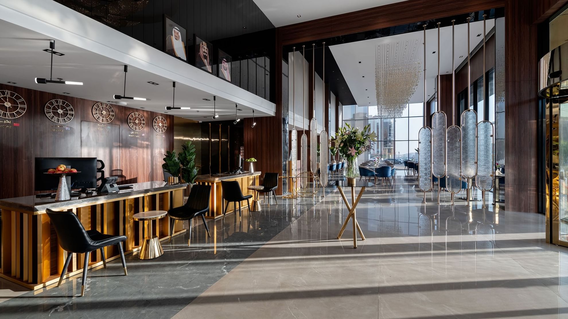 Modern hotel lobby with wooden reception desk, black chairs, glass wall, and decorative elements.