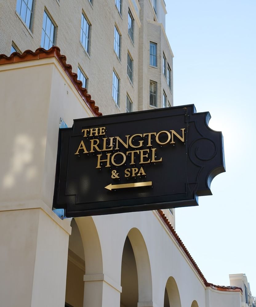 Black and gold Arlington Hotel & Spa sign mounted above arched walkways on the facade at Arlington Resort Hotel & Spa