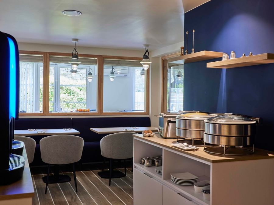Intérieur moderne d'un salon de thé avec chaises et tables à Hôtel La Marébaudière.