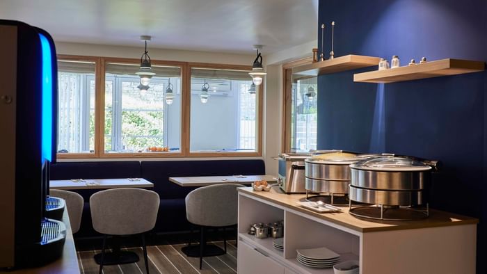 Intérieur moderne d'un salon de thé avec chaises et tables à Hôtel La Marébaudière.