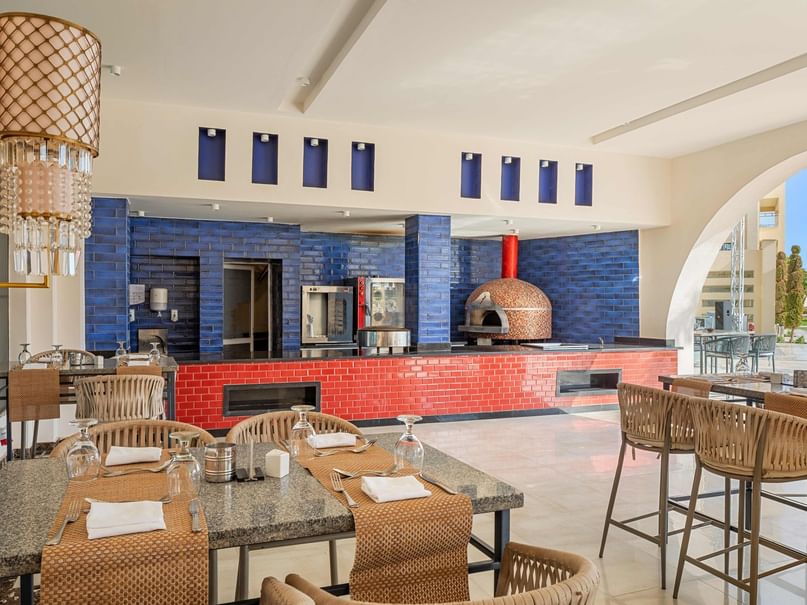 Restaurant interior with blue-tiled pizza oven and red brick counter at Pickalbatros White Beach Resort Hurghada