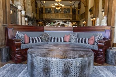 Cozy seating area featuring a curved wooden bench with a round textured coffee table at Hotel Park City Autograph Collection 