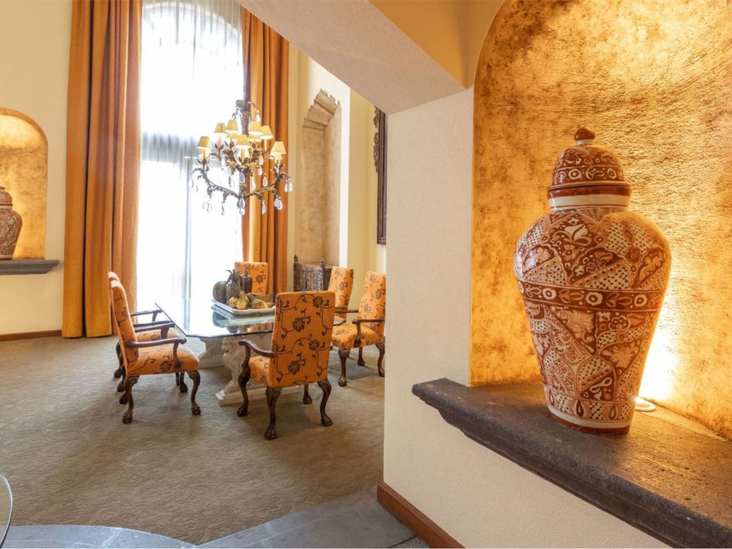 King Presidential Suite ceramic vase with a grand dining table and golden curtains at Quinta Real Monterrey