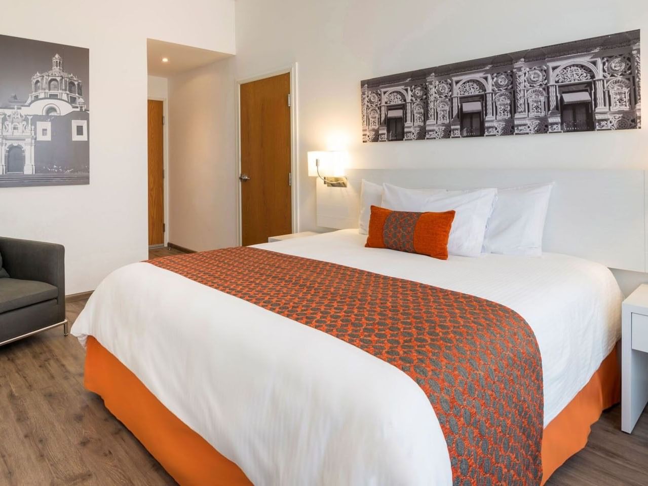 King Suite 1 Room room at Camino Real Puebla Angelopolis, featuring a plush bed and stylish wooden door entry area