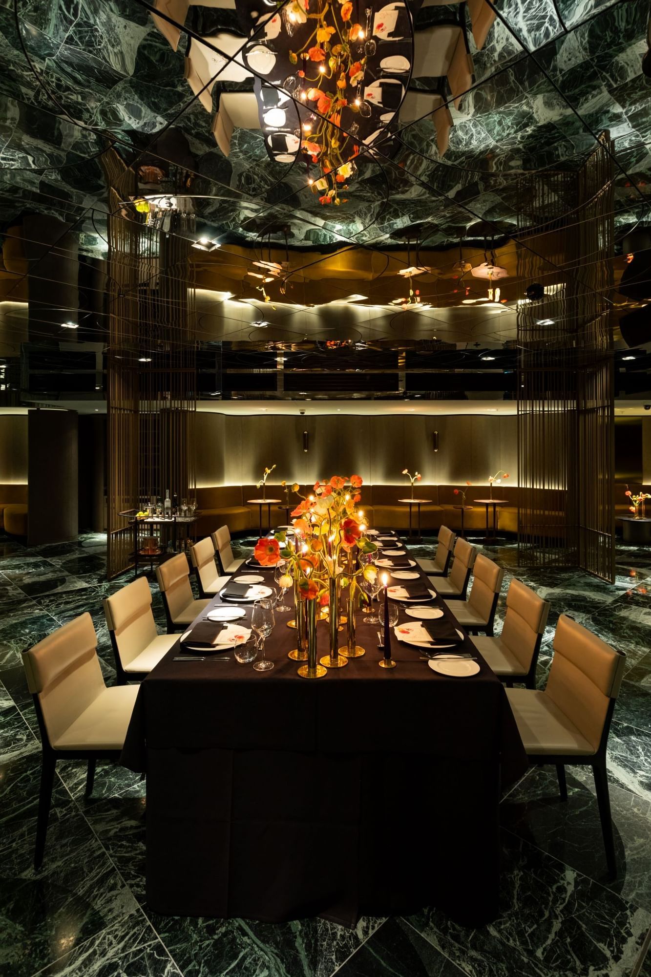 Elegant dining room at The Londoner Hotel with a long table, elegant chairs, and a sparkling chandelier