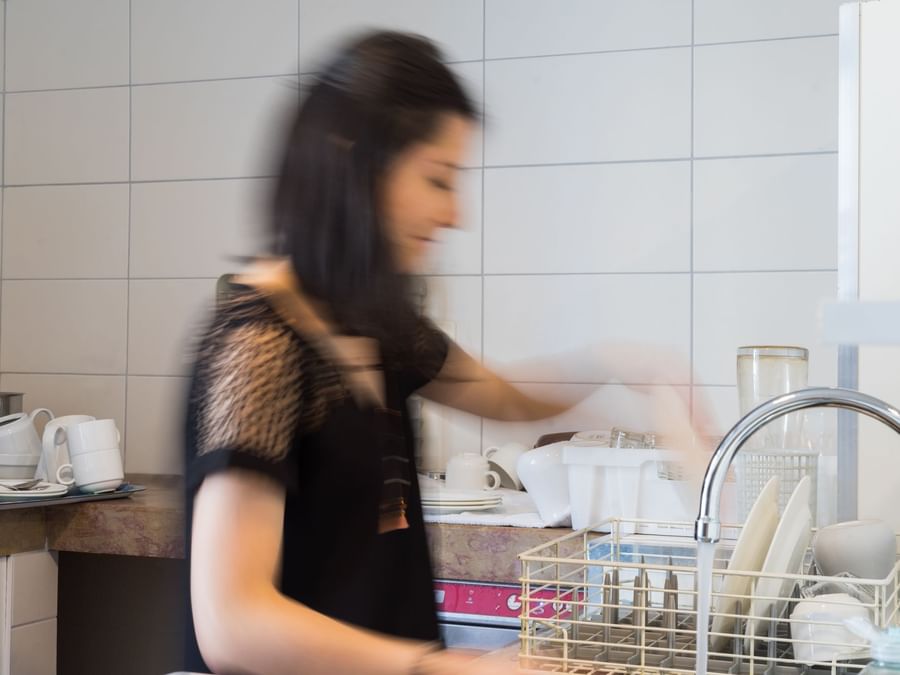 A maid cleaning plates in the kitchen at Hotel terminus