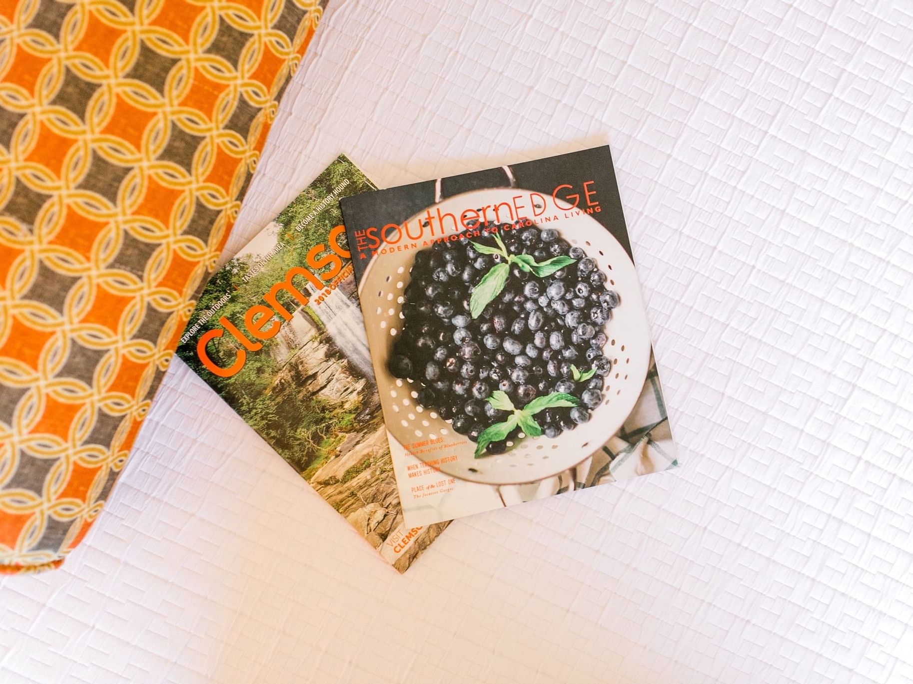 Two magazines on top of bed