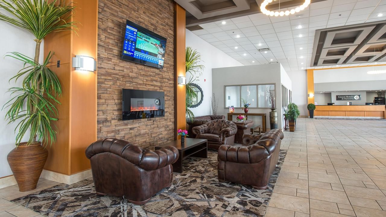 Lobby with fireplace and couches at Coast Lethbridge Hotel & Conference Centre.