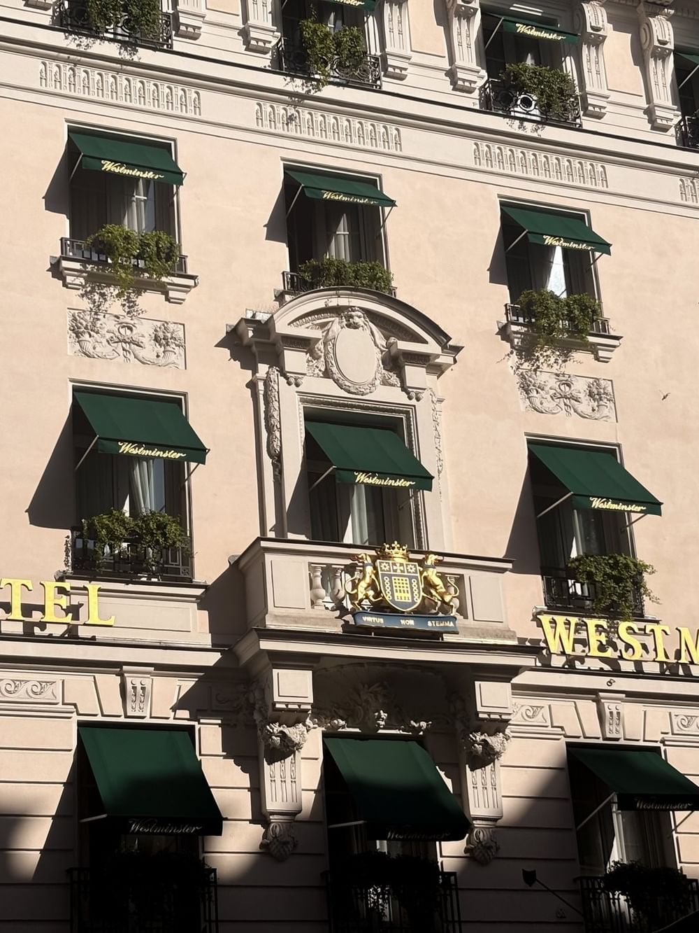 Historic Hotel Westminster Paris facade featuring green awnings over windows and a prominent hotel sign