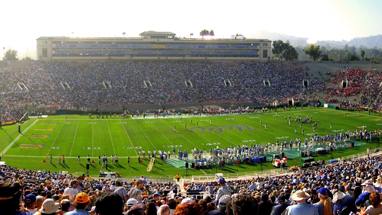 A packed stadium with a large crowd of spectators watching a football game.
